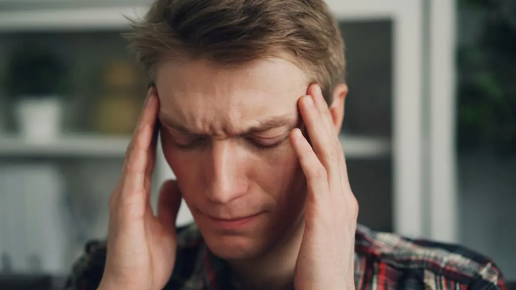 A man pressing his fingers to his temples