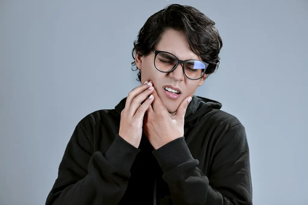A person holding both sides of their jaw