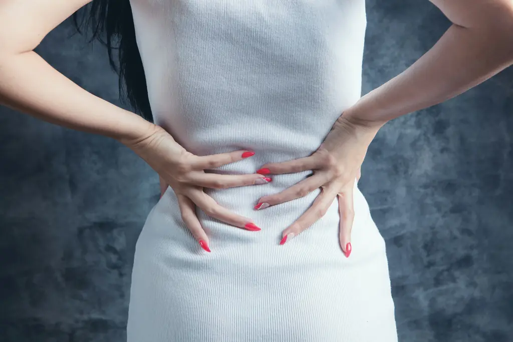 A person holding their lower back with both hands