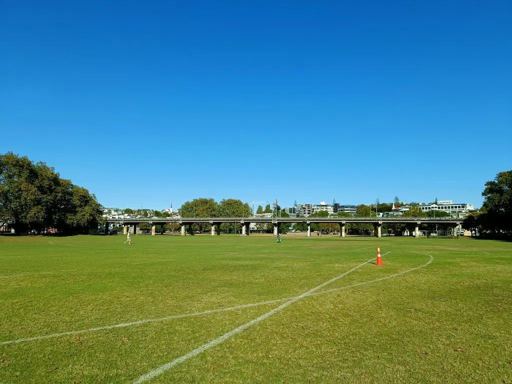 An empty sports field under a clear blue sky