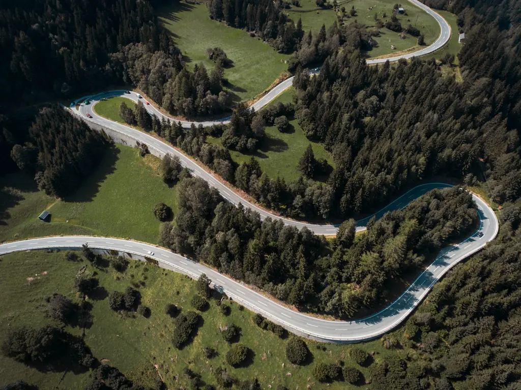 An aerial view of a road winding through forest
