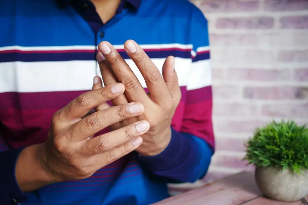A person rubbing their hand and wrist